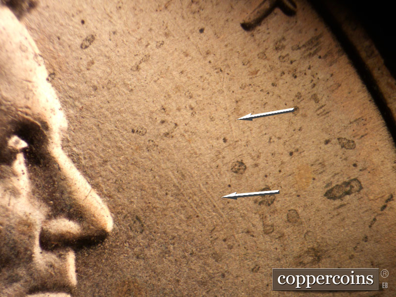 Die-stage B marker on 2021P•1DO•004 showing Die scratches in field in front of face.