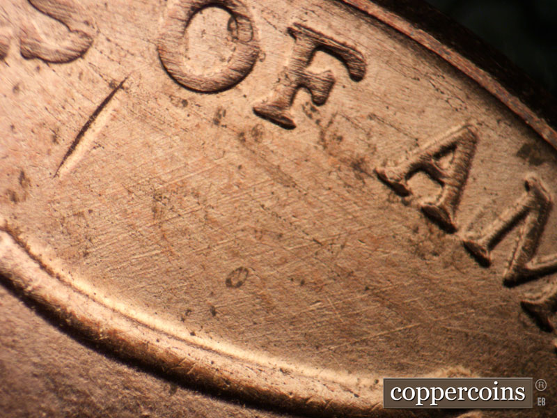 Die-stage A marker on 2021P•1DR•001 showing NE die scratches from top of shield.