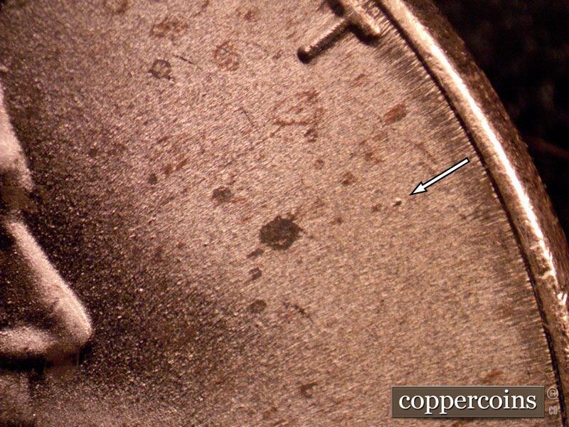 Die-stage B marker on 2022D•1DR•001 showing Die dot near last T in TRUST.