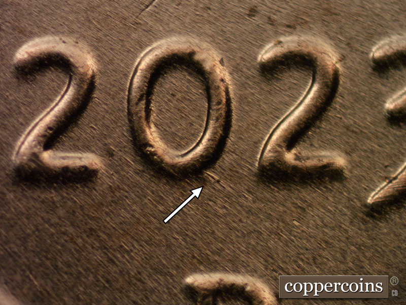 Die-stage B marker on 2023D•1DR•001 showing SE die gouge from 0 in date.