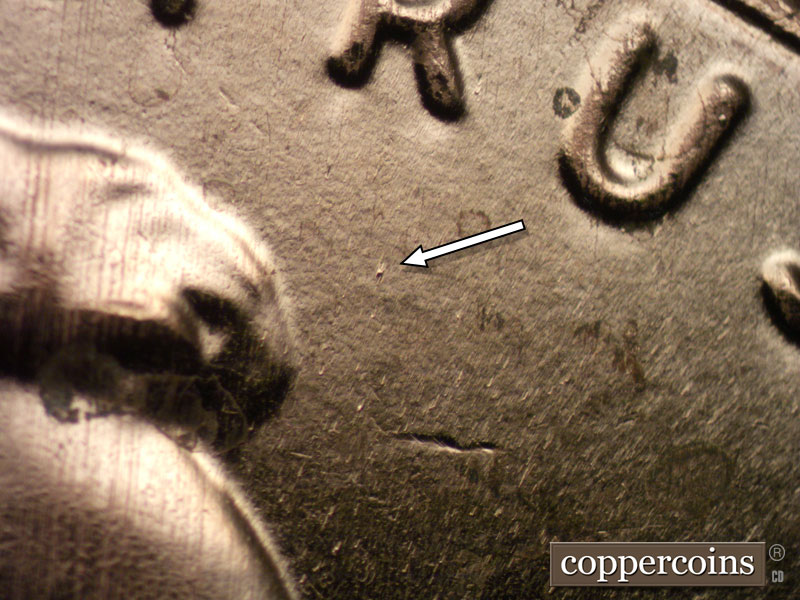 Die-stage B marker on 2024D•1DO•001 showing Specific die dots show in front of the hair under the R of TRUST and in front of the nose.
