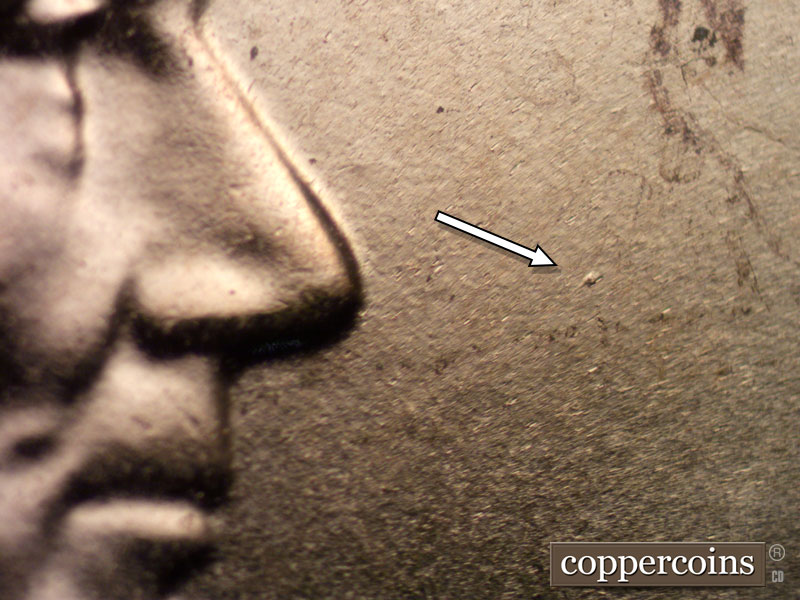 Die-stage B marker on 2024D•1DO•001 showing Specific die dots show in front of the hair under the R of TRUST and in front of the nose.