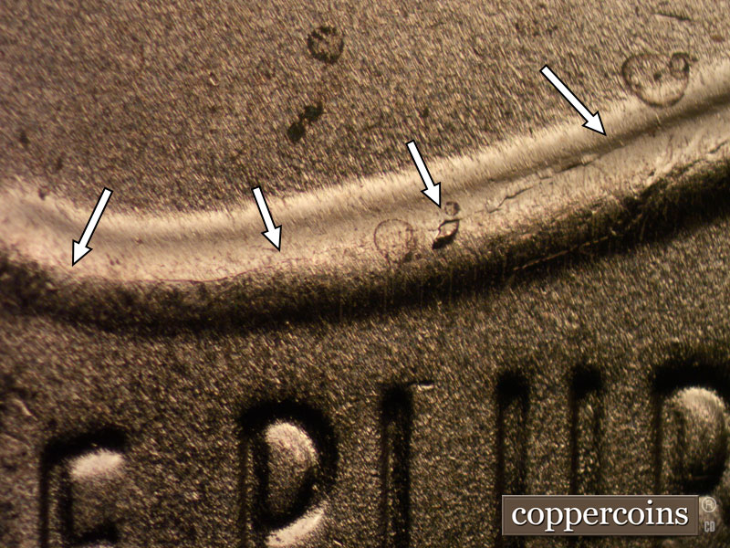 Die-stage B marker on 2024D•1DR•001 showing Die crack on top of shield.