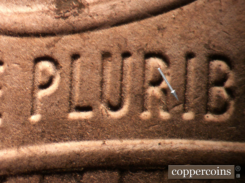 Die-stage C marker on 2024P•1DO•001 showing Die gouge or crack through RIB in PLURIBUS.