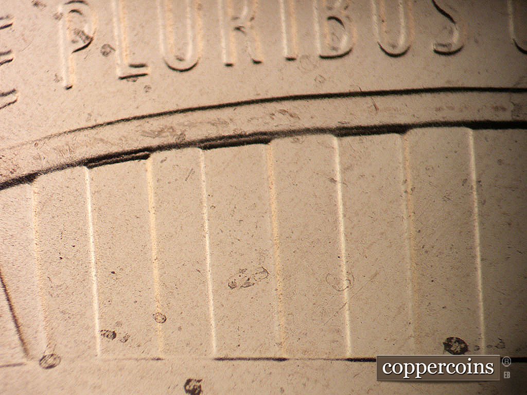 Die-stage B marker on 2024P•1DR•001 showing An extra shield crown lower border shows inside the tops of bars 5, 7, and 9 of the shield.