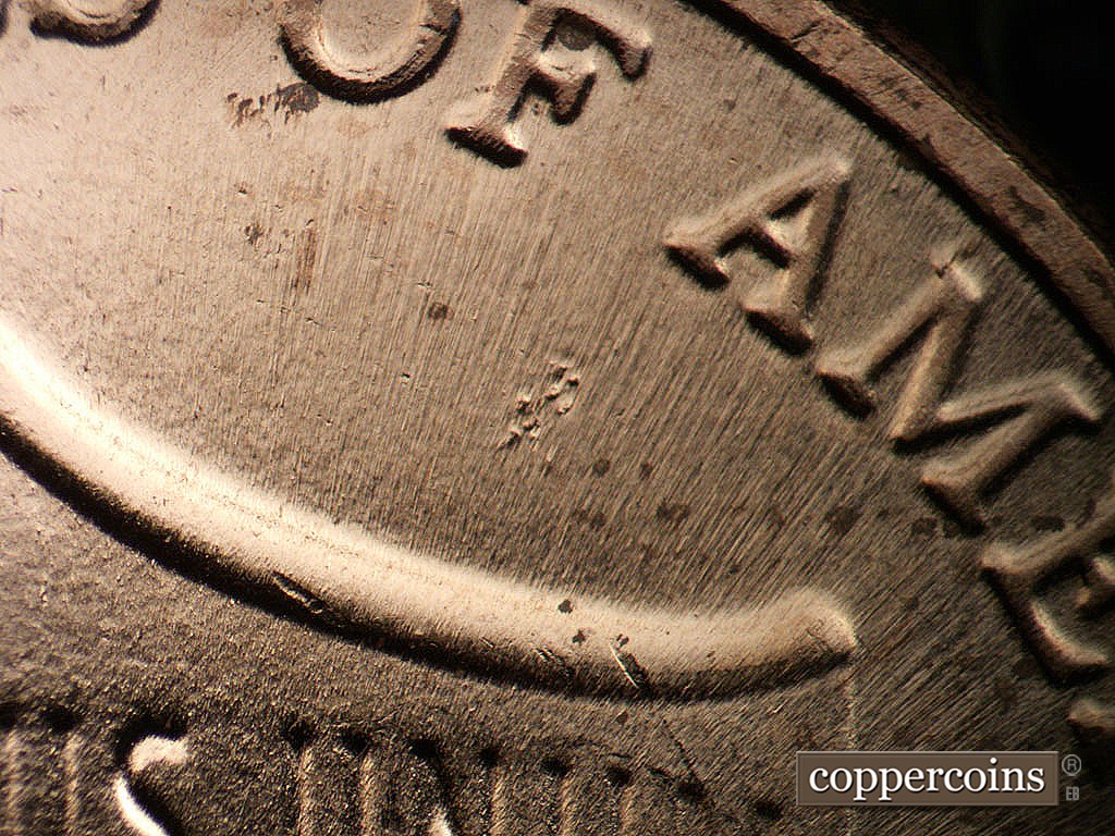 Die-stage B marker on 2024P•1DR•001 showing Die pitting in field under first A in AMERICA.