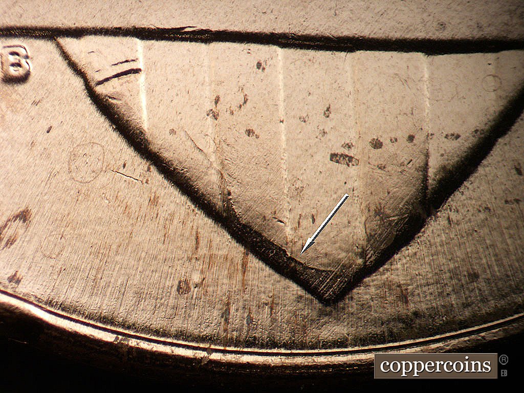 Die-stage B marker on 2024P•1DR•001 showing Die crack on lower tip of shield.