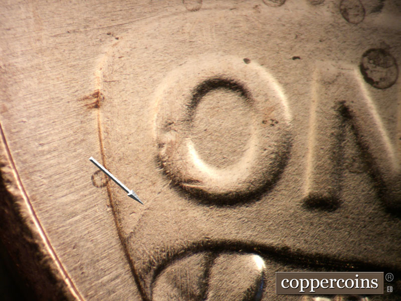 Die-stage B marker on 2025P•1DO•001 showing Die crack from O in ONE.